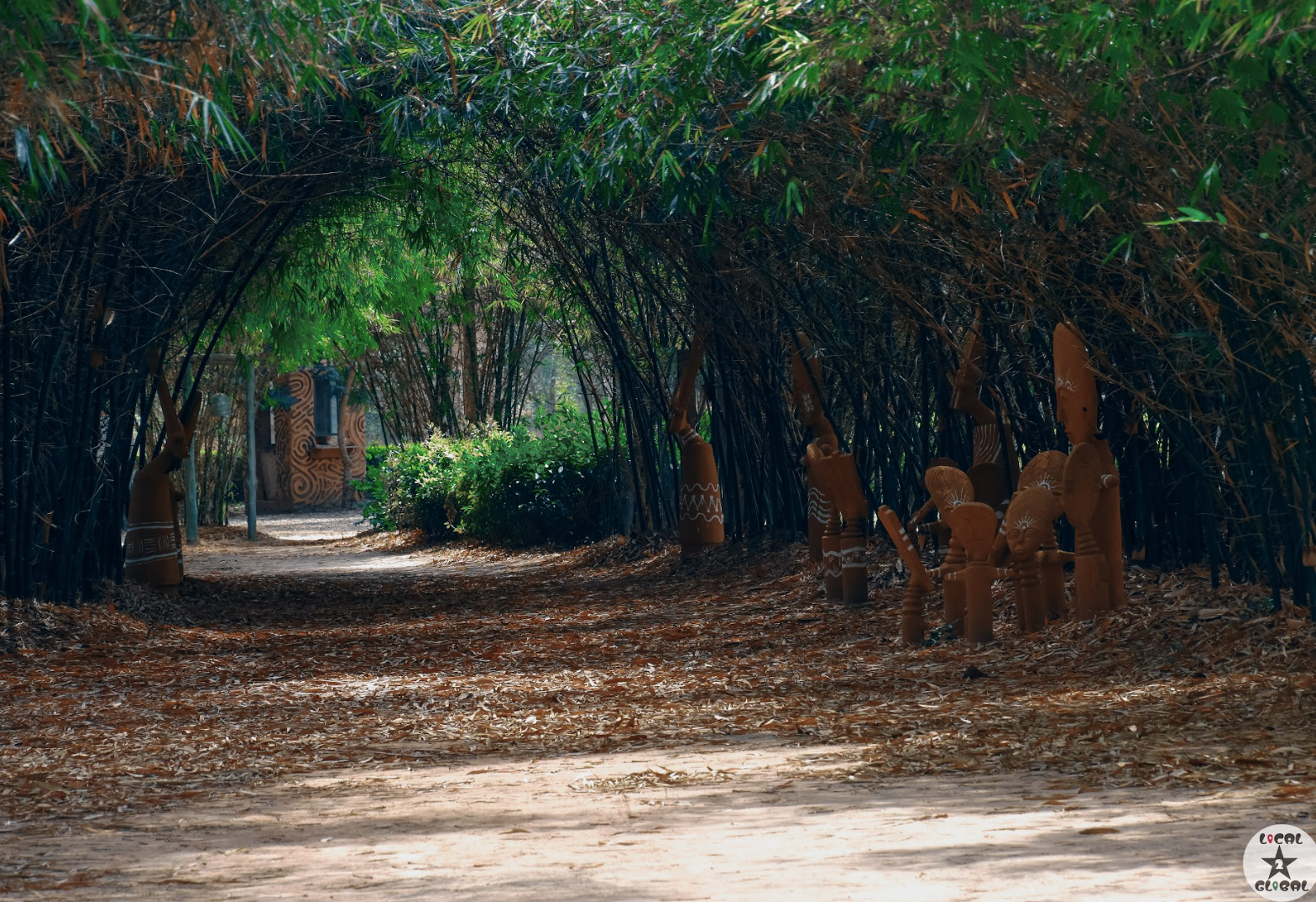 Cultural sculptures along a tree-lined path